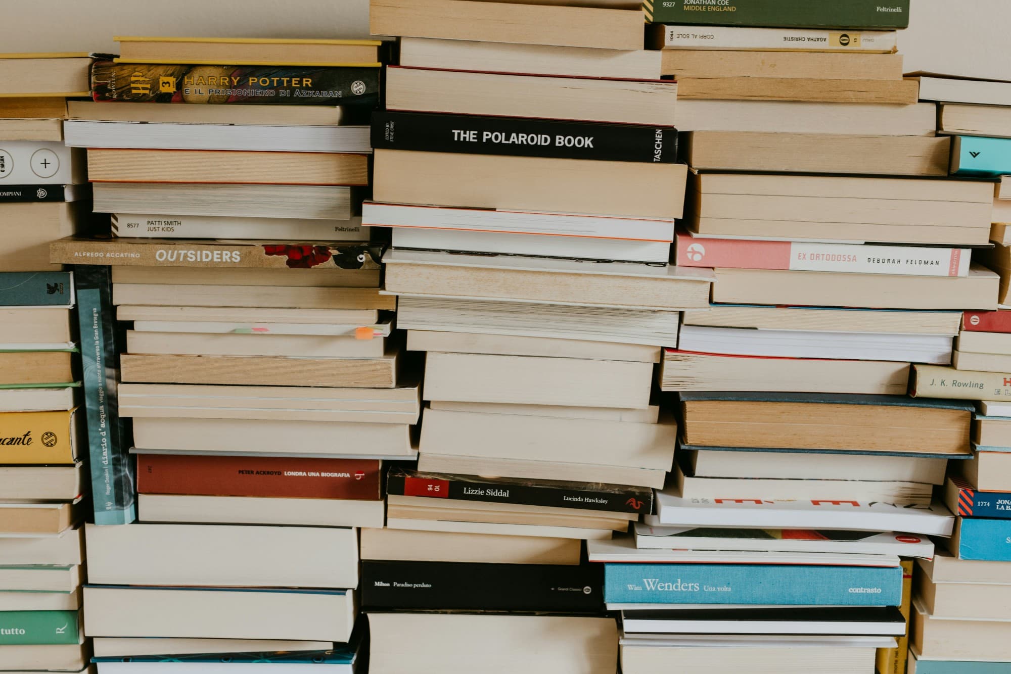 Stacks of books piled against a wall