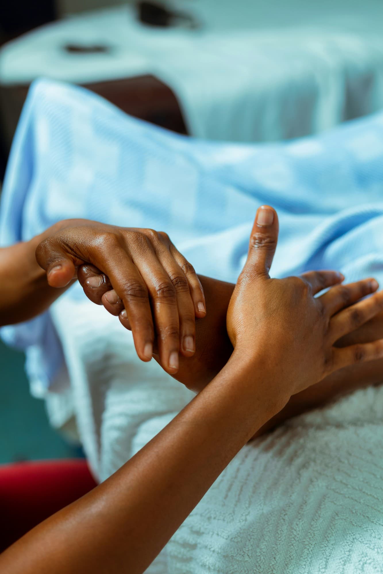 A therapist's hands guiding a client's hand and wrist during therapy