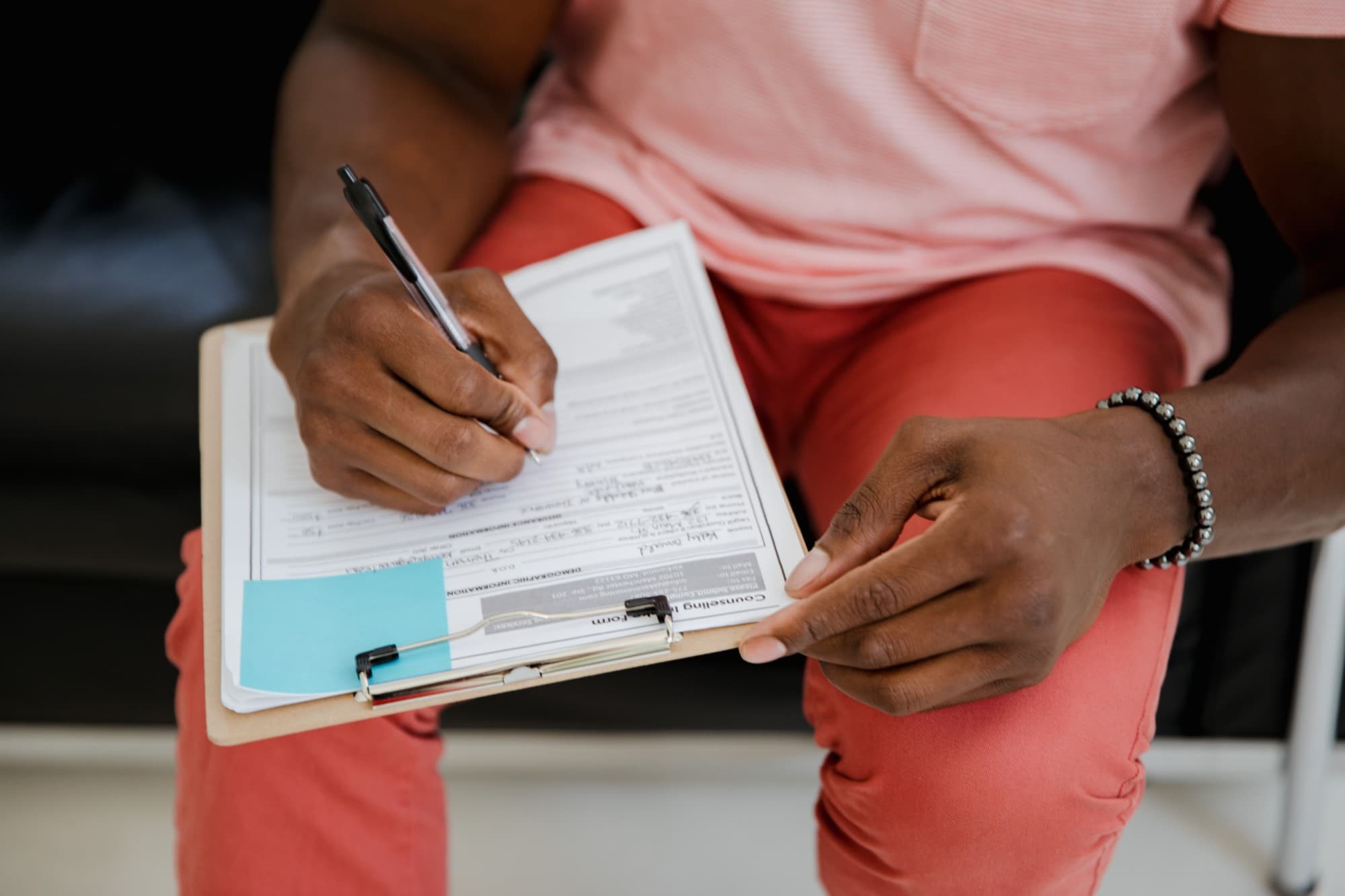 A person filling in a form on a clipboard